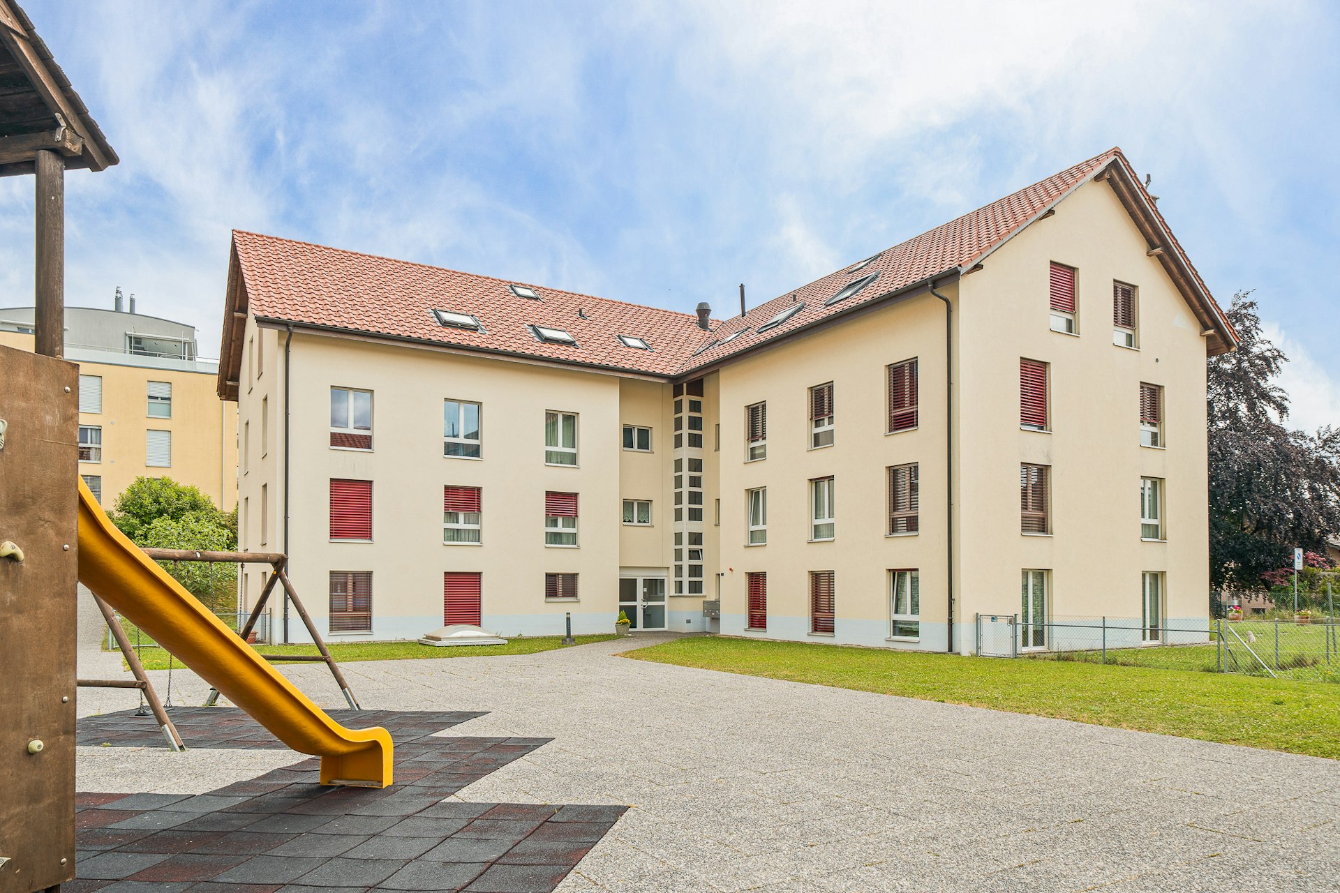 Außenansicht eines Wohngebäudes mit Spielplatz