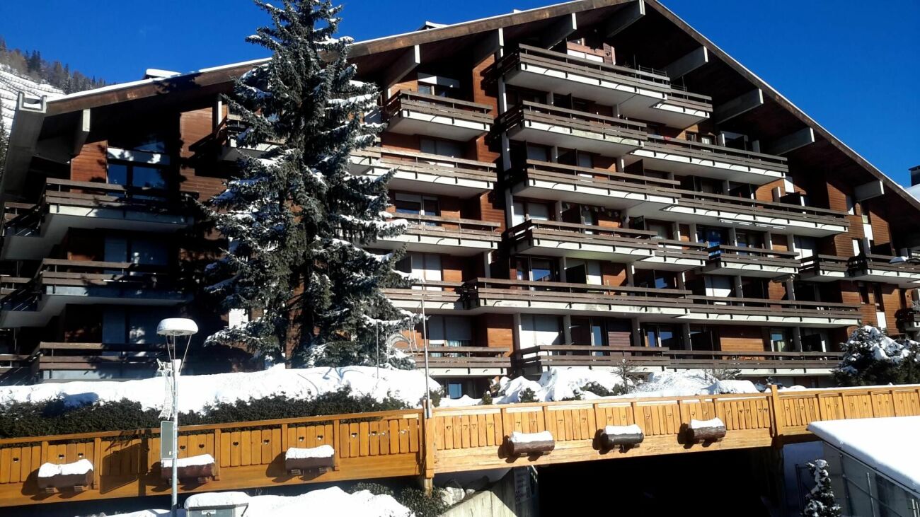 Alpines Mehrfamilienhaus mit Balkonen im Schnee