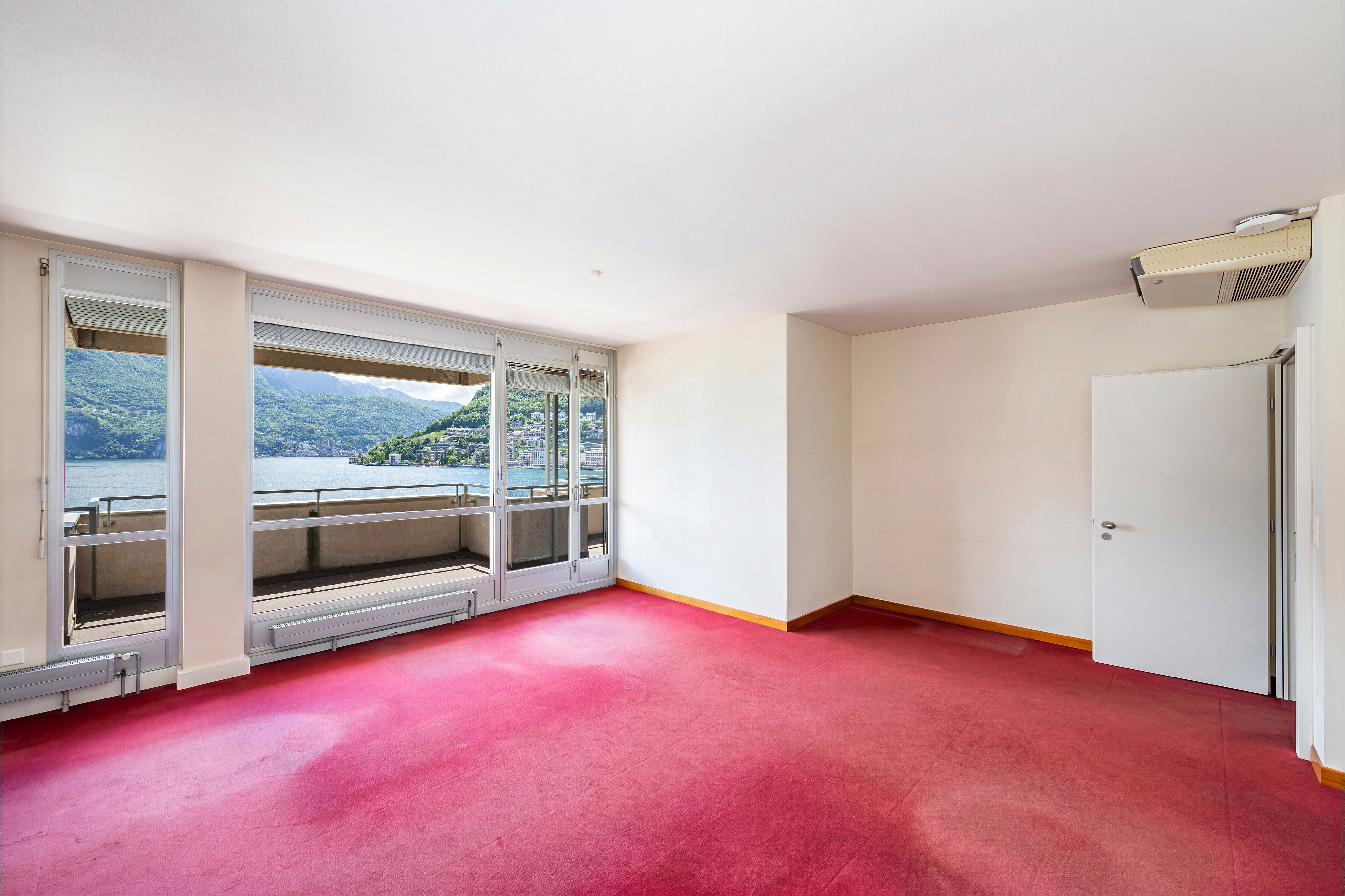 Leerer Wohnraum mit Balkon und Seeblick
