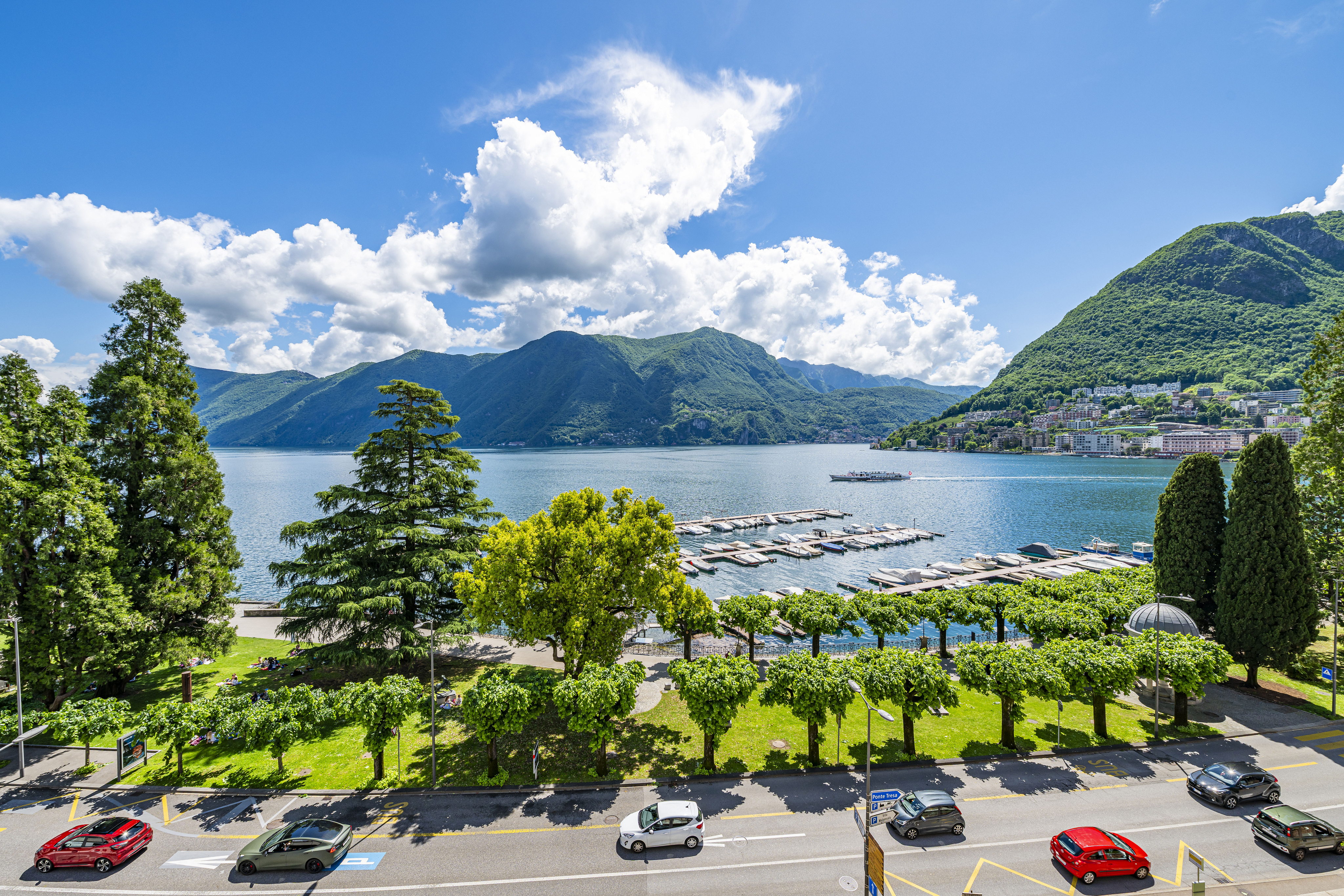 Seeblick mit Bergen und Uferpromenade