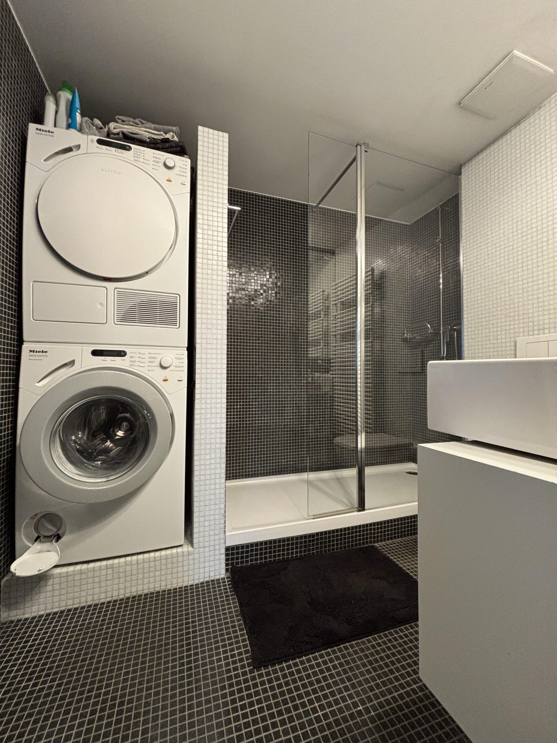 Modernes Badezimmer mit Waschmaschinen und Dusche