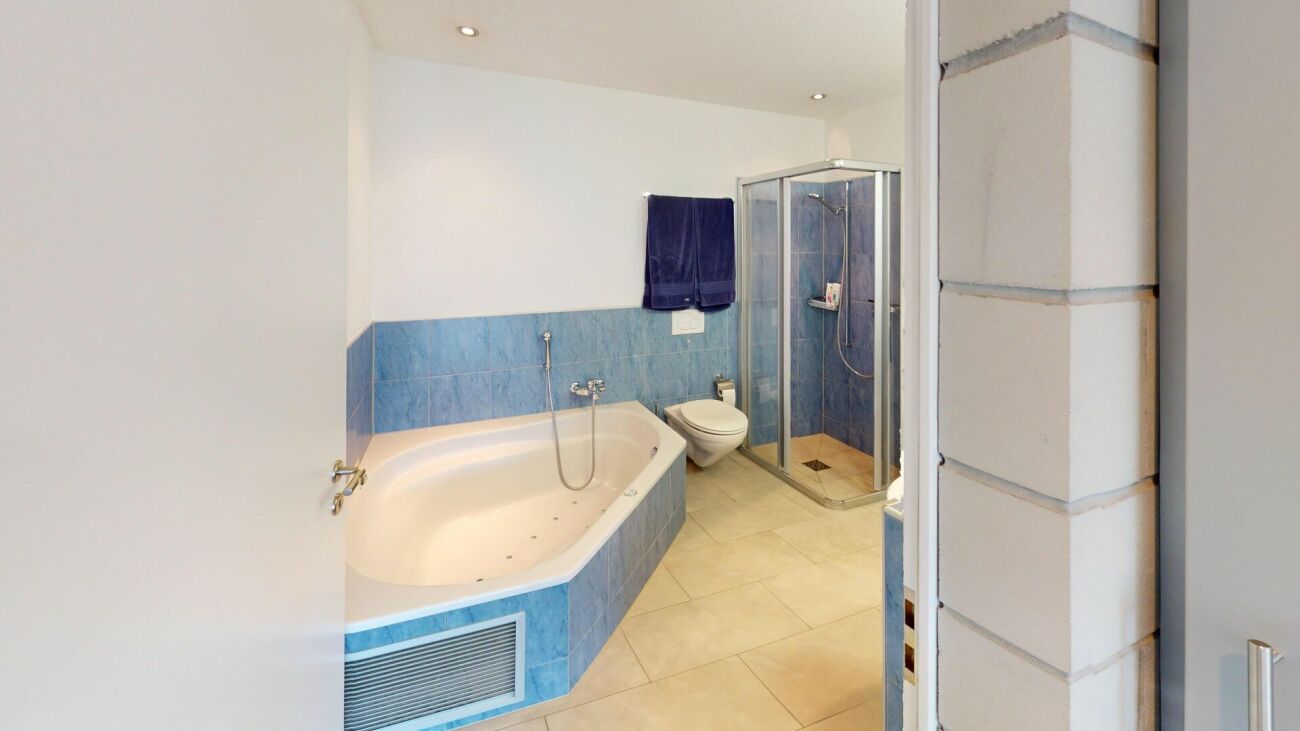 Modernes Badezimmer mit Whirlpoolwanne und Duschkabine