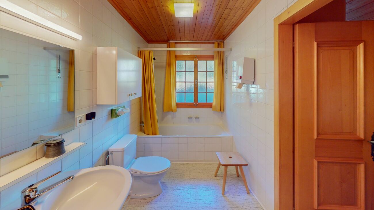 Badezimmer mit Holzdecke und gelben Vorhängen