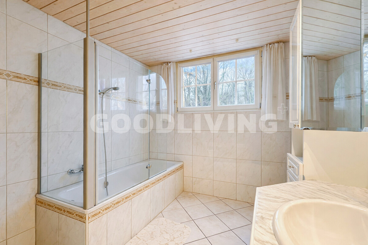 Helles Badezimmer mit Badewanne und Fenster