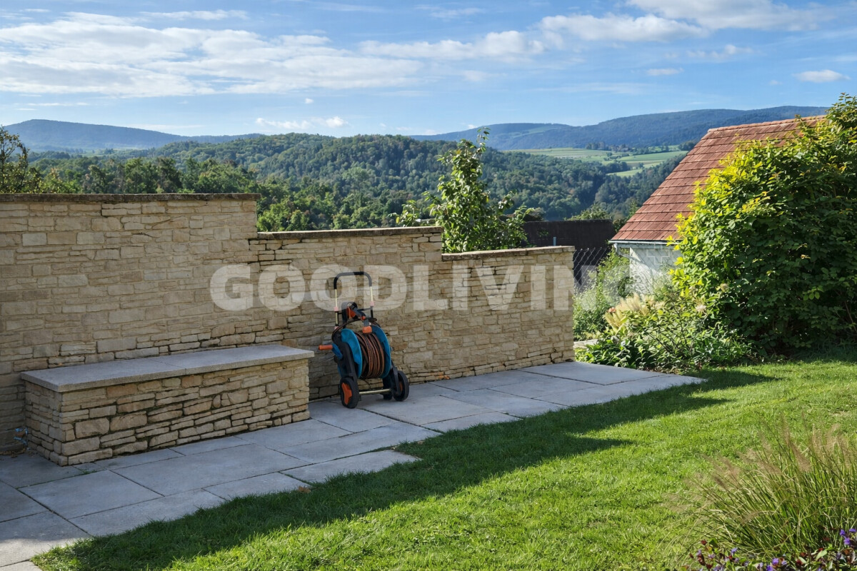 Garten mit Steinmauer und Bergblick