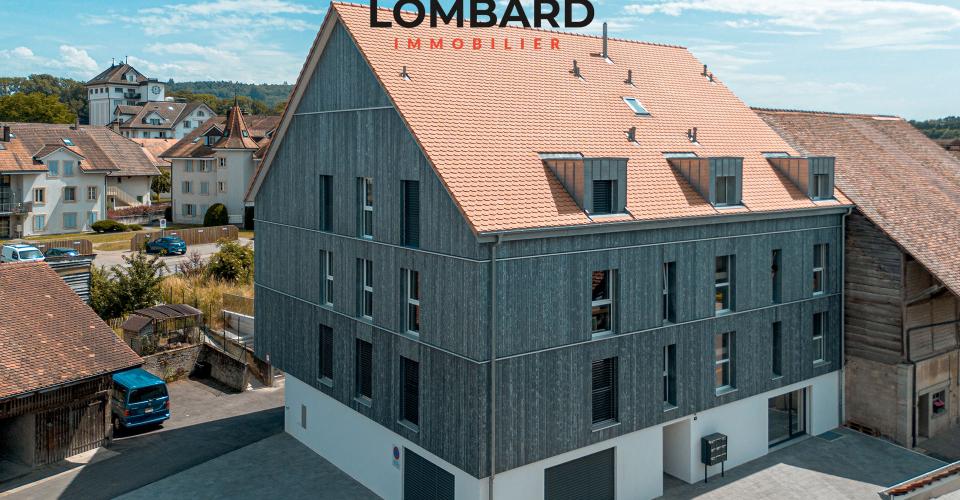 Außenansicht eines modernen Wohngebäudes mit Holzfassade und Satteldach