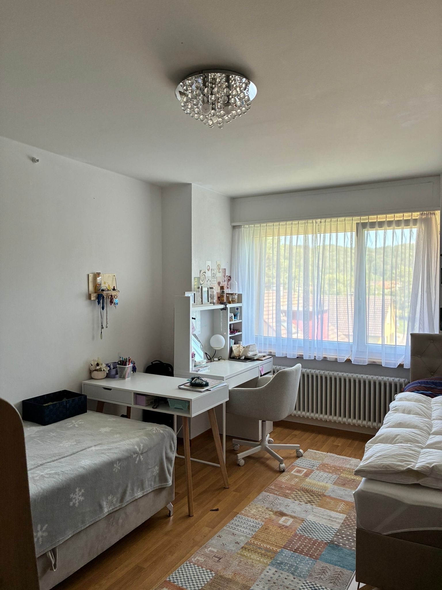 Hell eingerichtetes Schlafzimmer mit Arbeitsplatz
