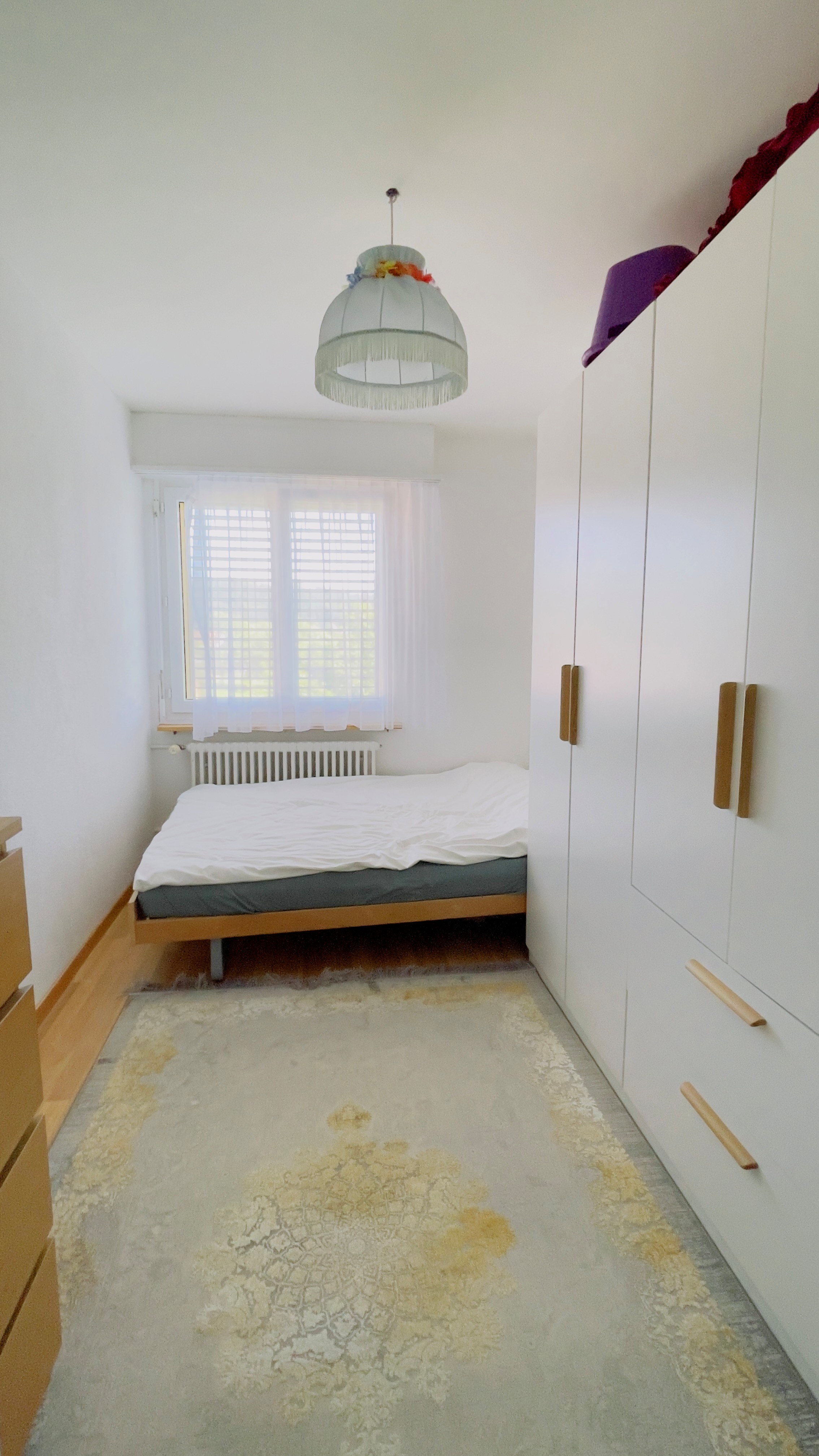 Schmales Schlafzimmer mit Bett und Einbauschrank