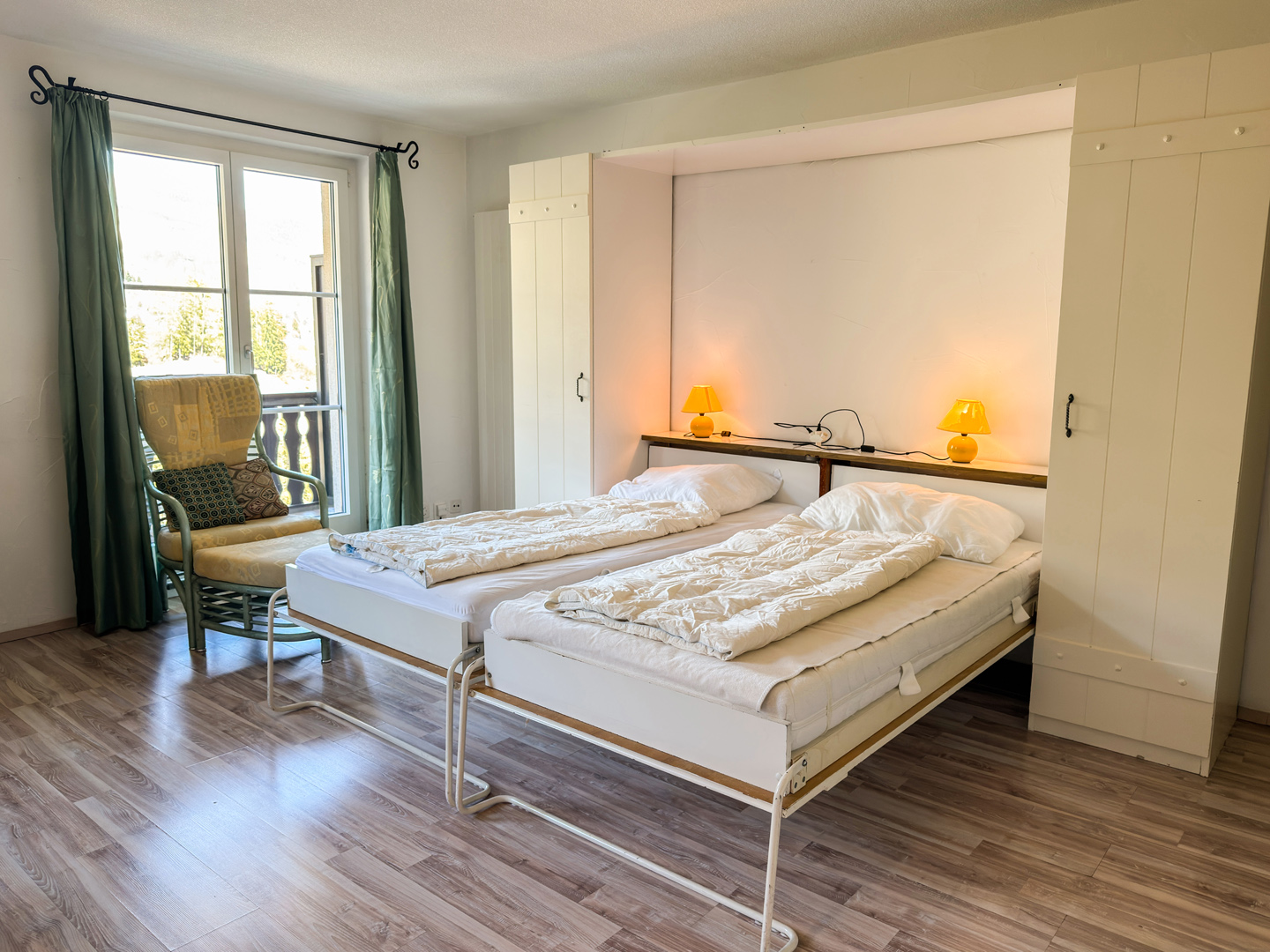 Helles Schlafzimmer mit zwei Einzelbetten und Balkonfenster