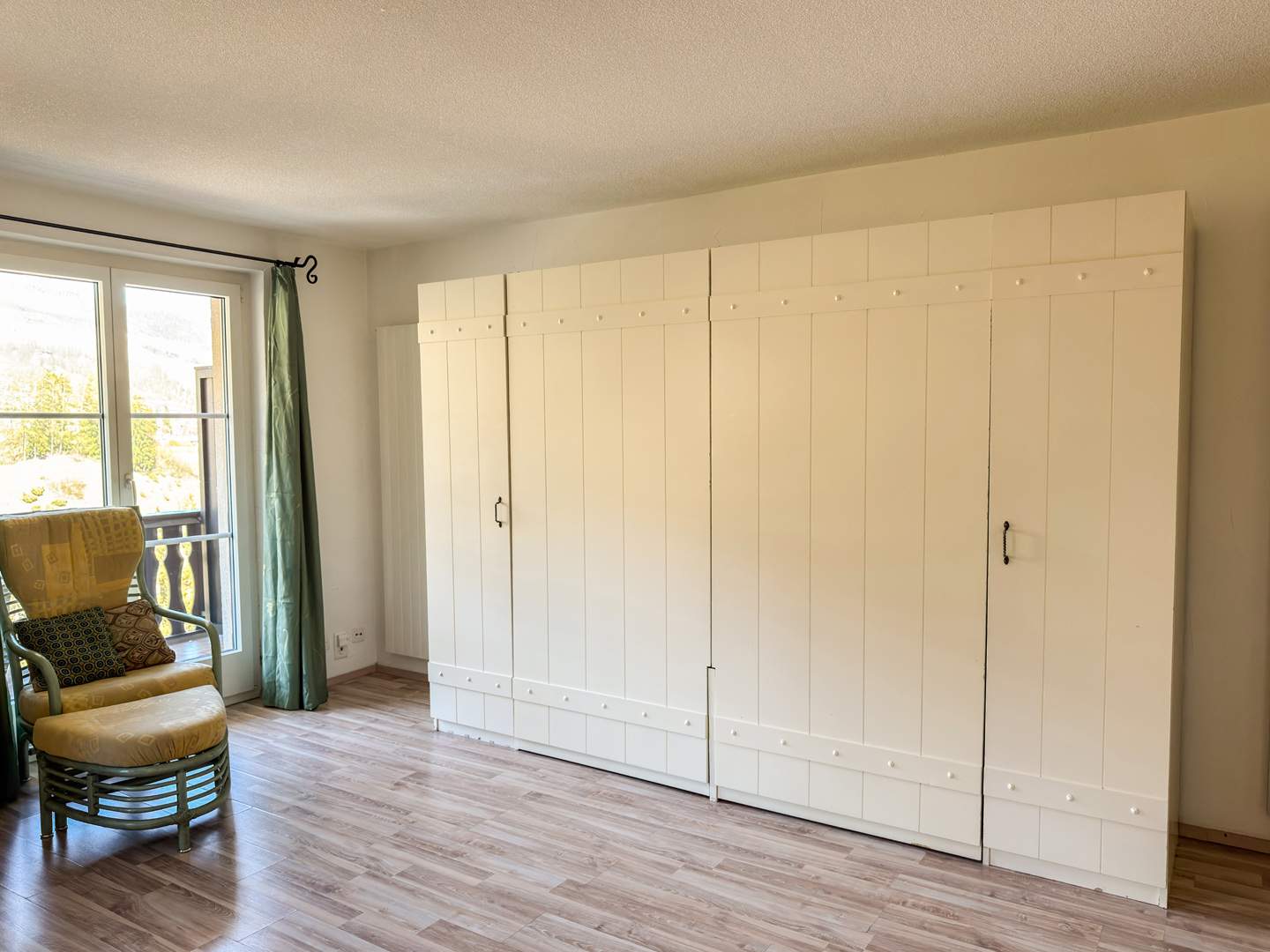 Helles Zimmer mit großem Schrank und Sessel