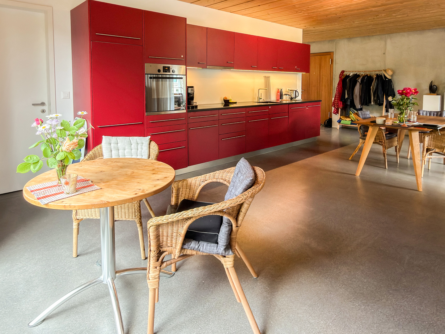 Offener Wohn-Ess-Küchenbereich mit roter Küchenzeile