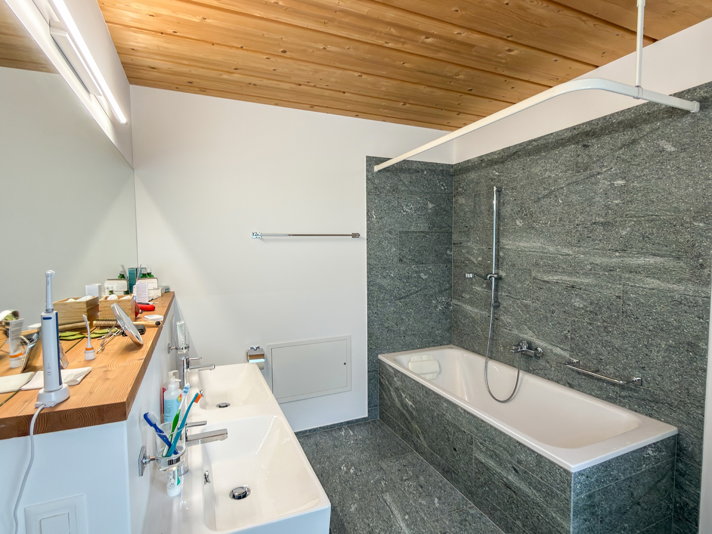 Modernes Badezimmer mit Badewanne und Holzdecke