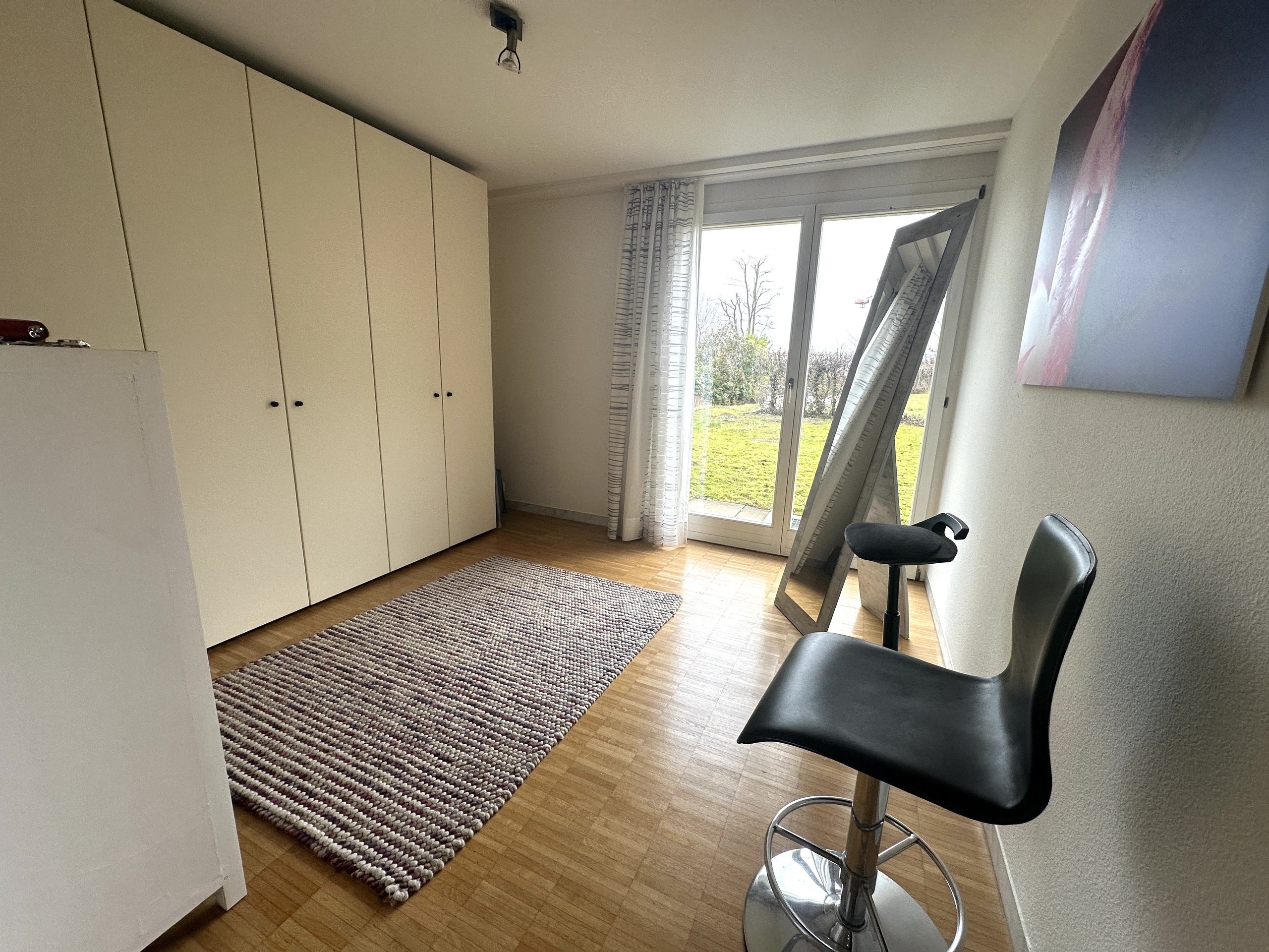 Helles Zimmer mit Schrankwand und Gartentür