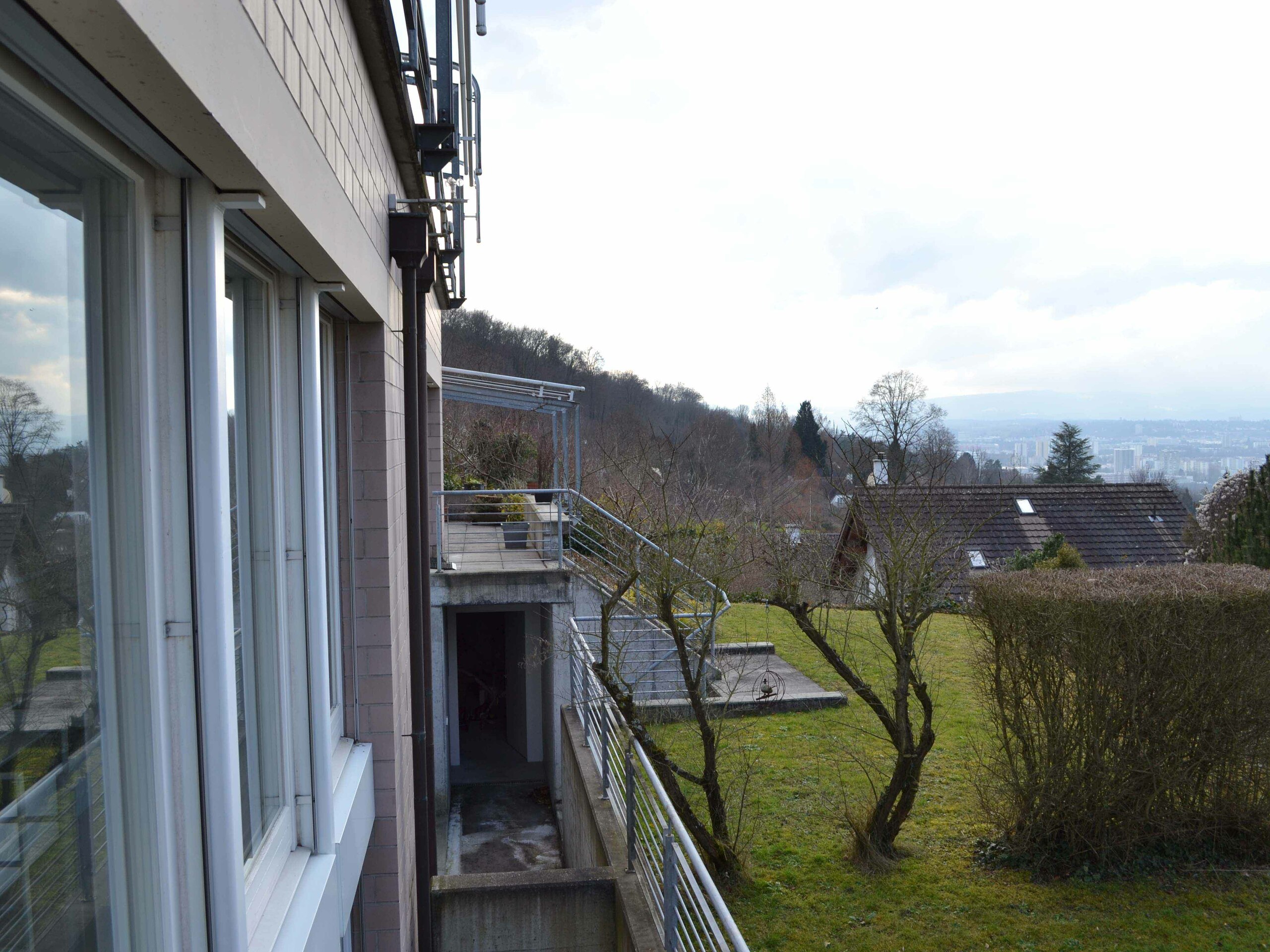 Außenansicht mit Balkon und Gartenhang