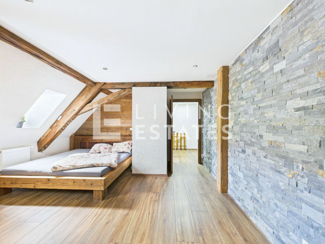 Schlafzimmer mit sichtbaren Holzbalken und Steinwand