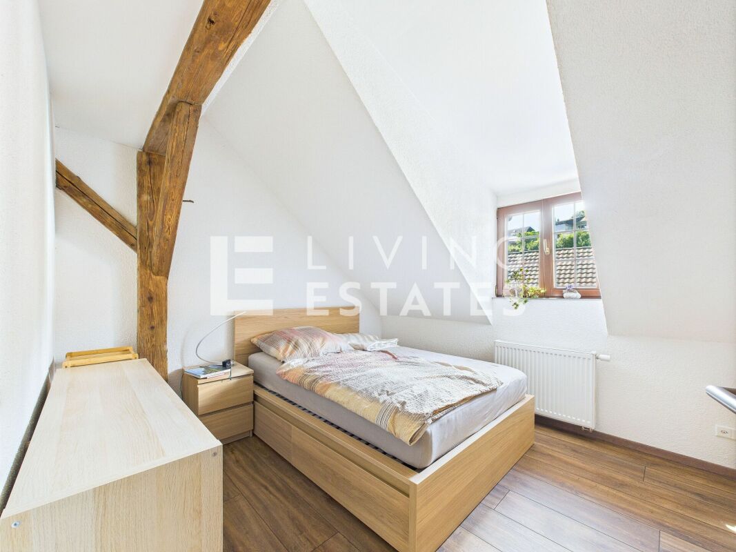 Dachgeschoss-Schlafzimmer mit sichtbaren Holzbalken