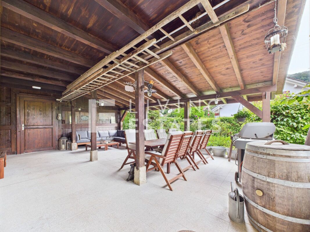 Überdachte Terrasse mit rustikaler Holzdecke