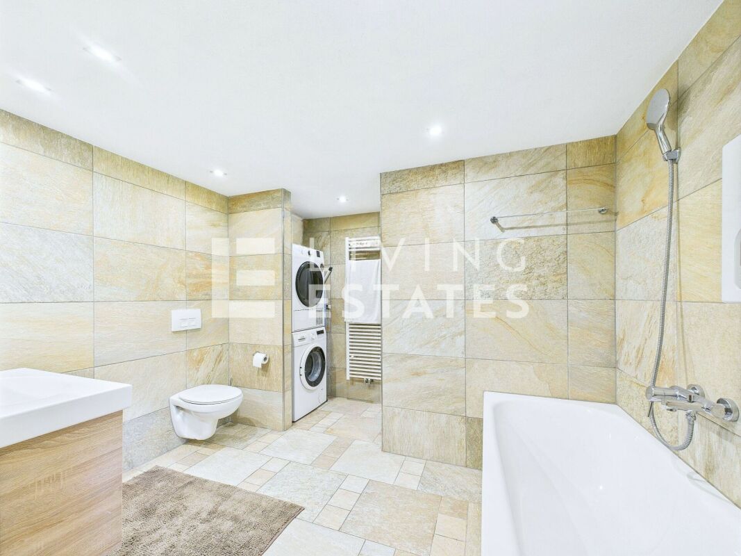 Modernes Badezimmer mit Badewanne, WC und Waschturm