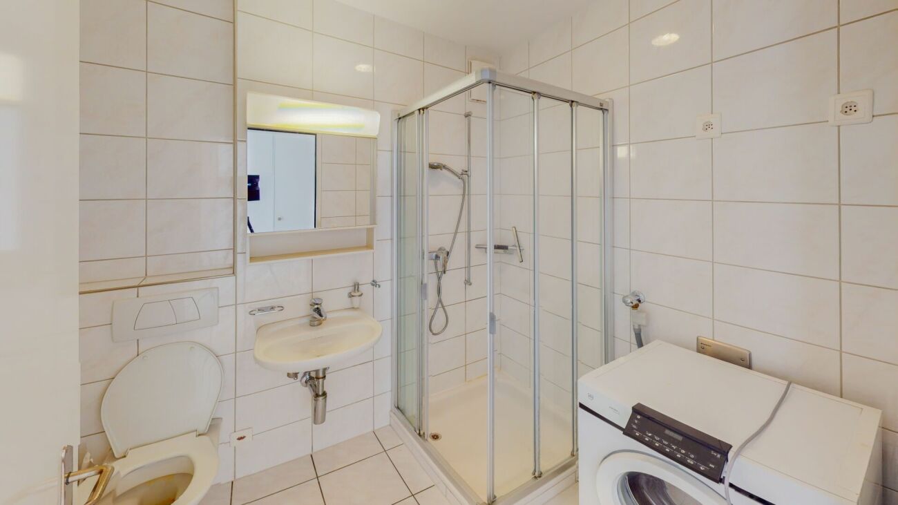 Modernes Badezimmer mit Dusche und Waschmaschine