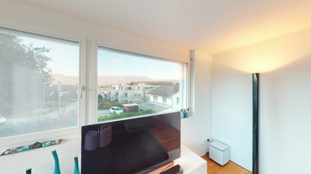 Helles Zimmer mit großen Fenstern und Blick ins Grüne
