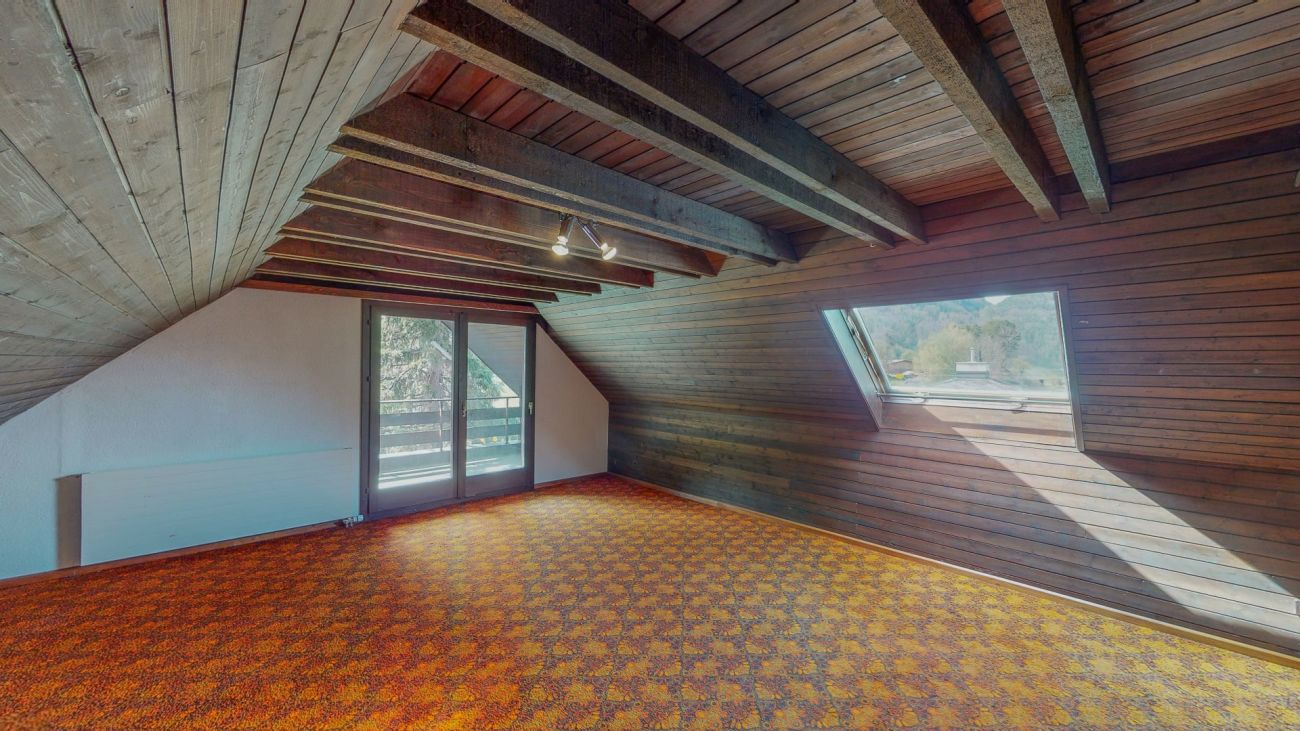 Dachgeschossraum mit Holzverkleidung und Teppichboden
