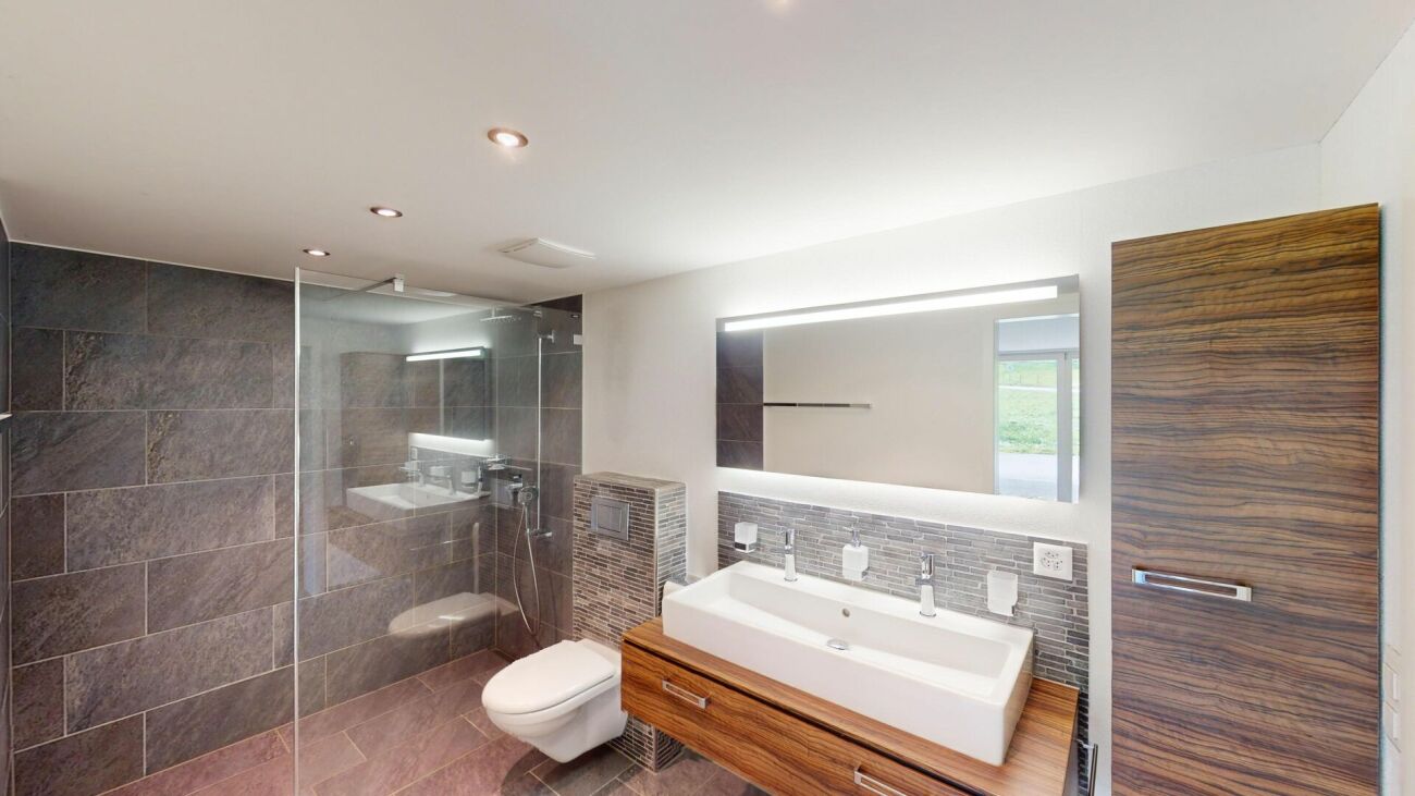 Modernes Badezimmer mit bodengleicher Dusche und Holzdetails