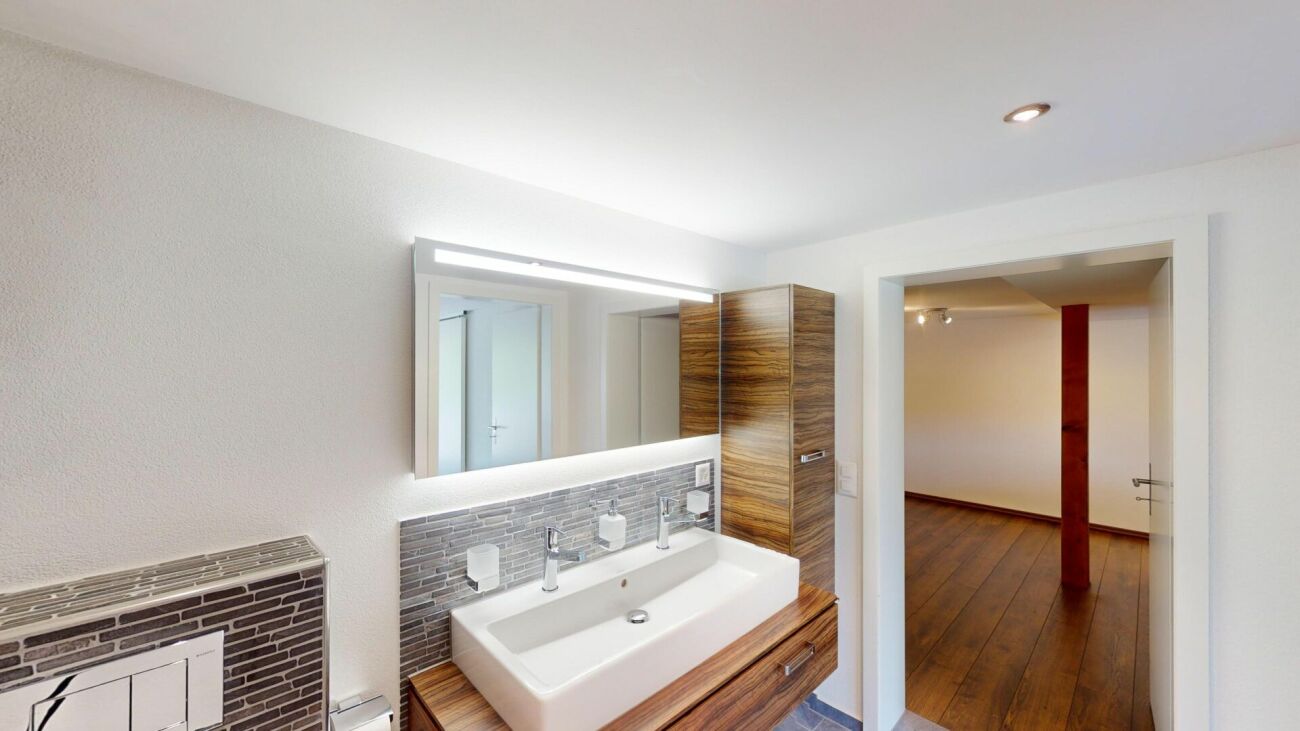 Modernes Badezimmer mit Blick in angrenzenden Raum