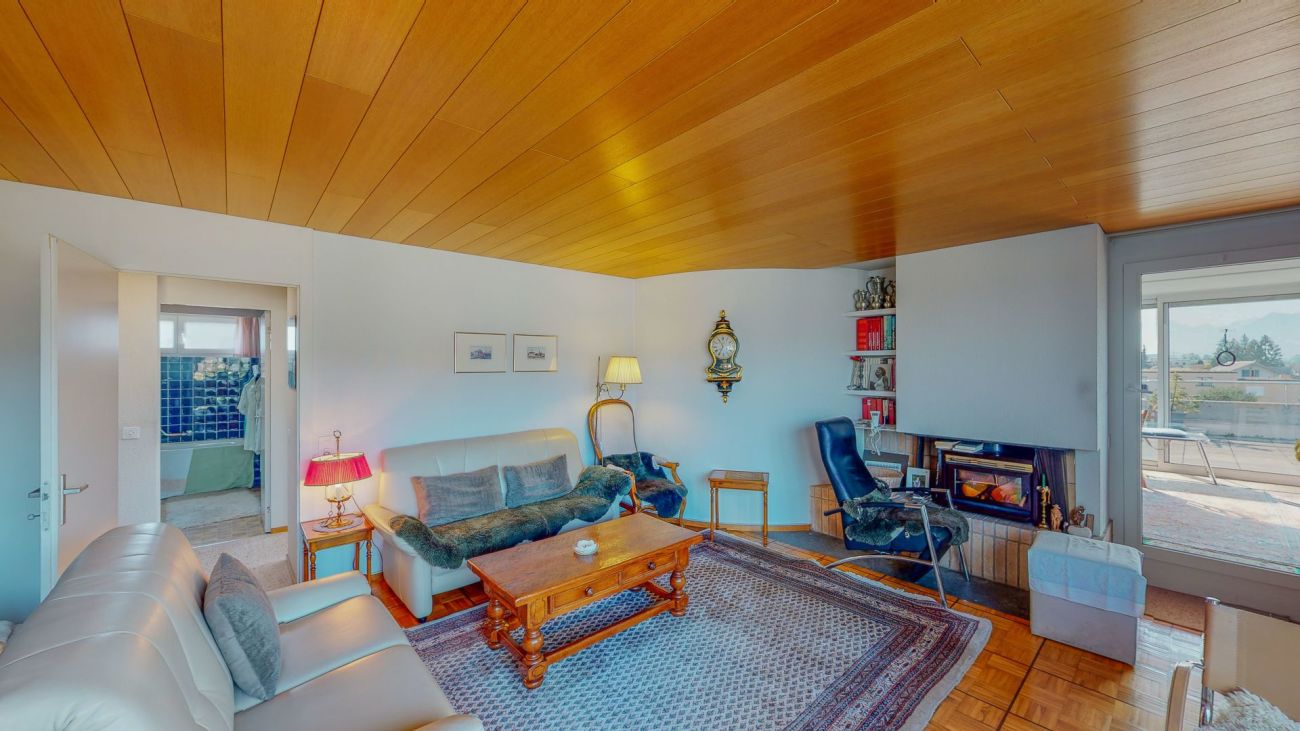 Wohnzimmer mit Kamin und Balkonblick