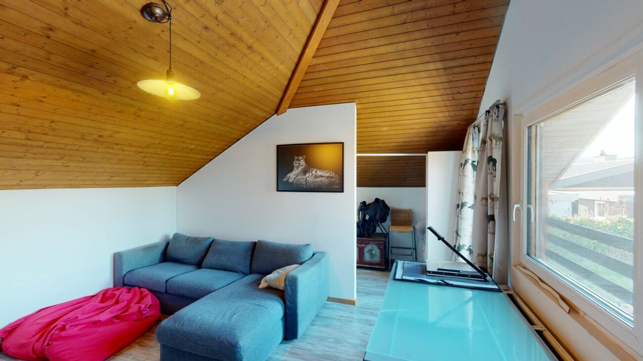 Dachgeschoss-Wohnraum mit Sofa und Fenster