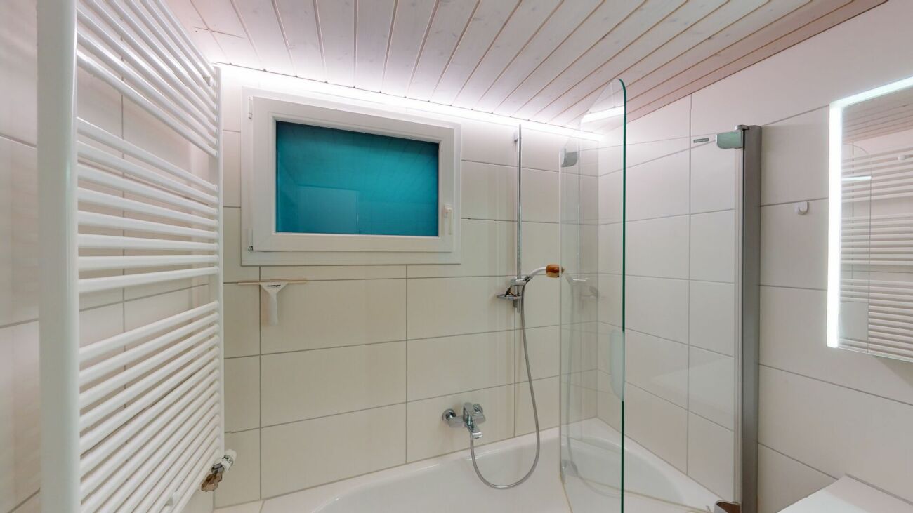 Modernes Badezimmer mit Badewanne und Glasabtrennung