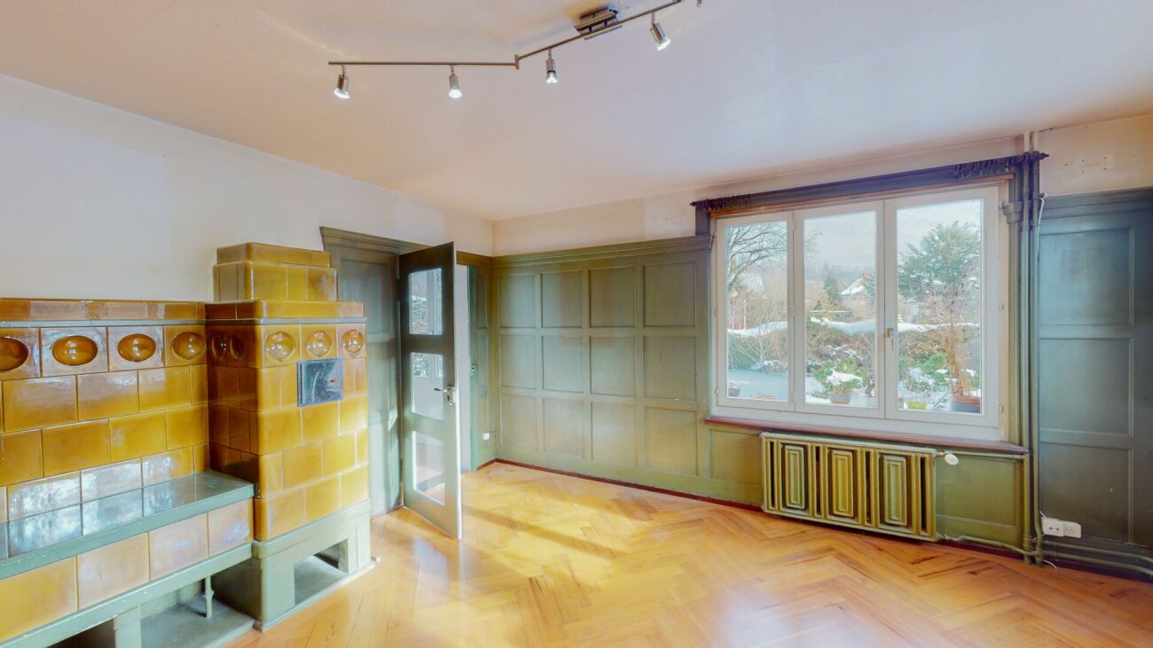 Wohnraum mit Kachelofen und Fenster