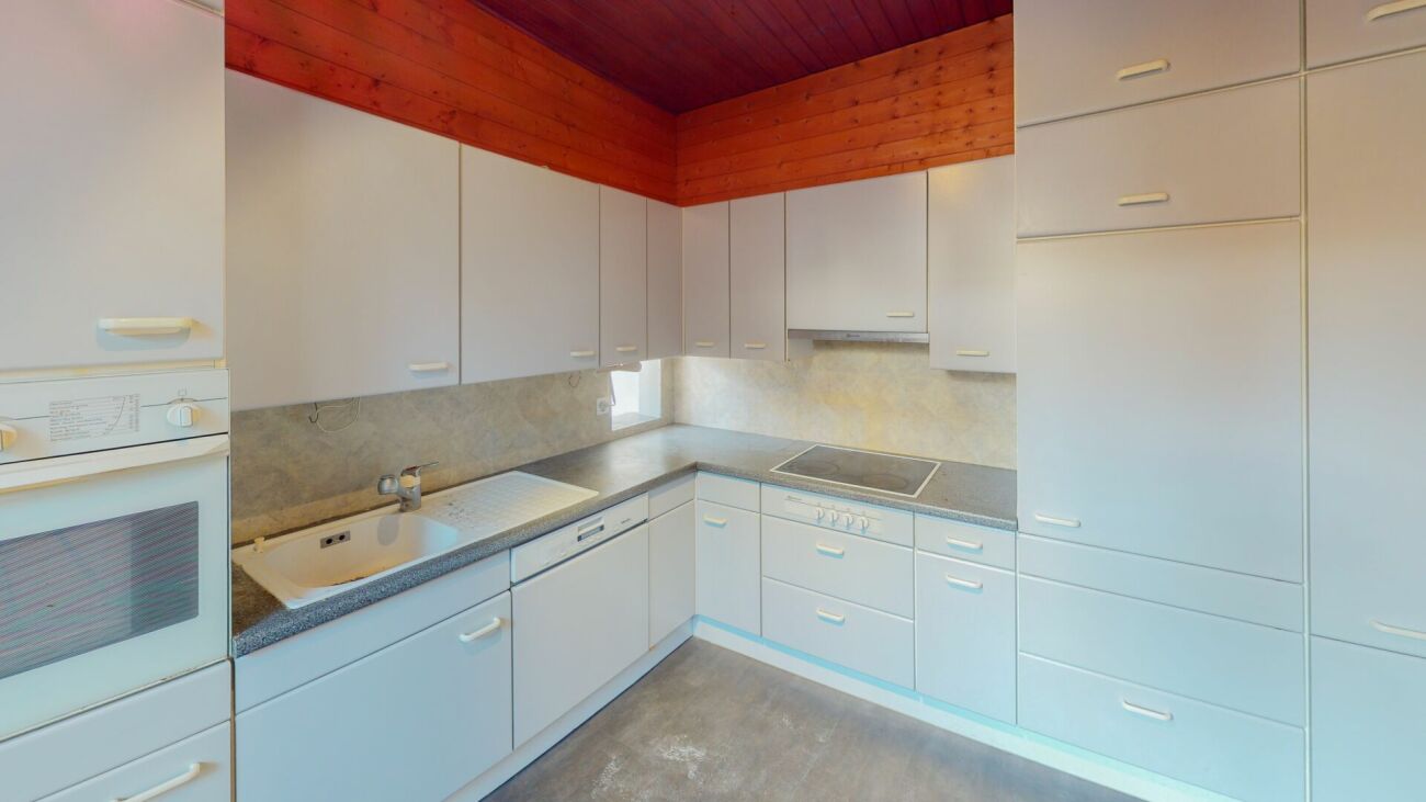 Weiße Einbauküche mit Holzdecke
