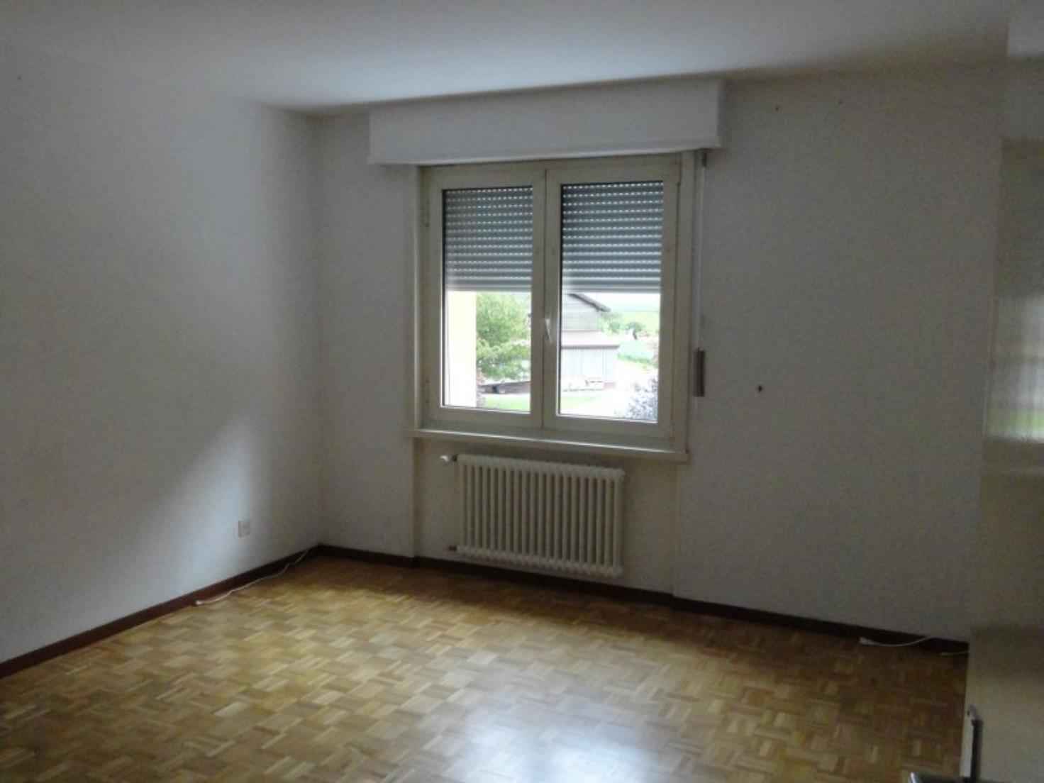 Leerer Wohnraum mit Fenster und Heizkörper
