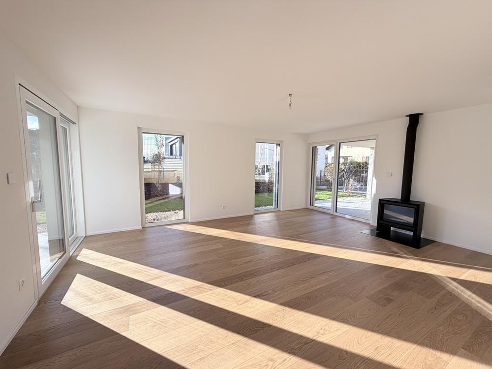 Heller Wohnraum mit Kamin und Gartenblick