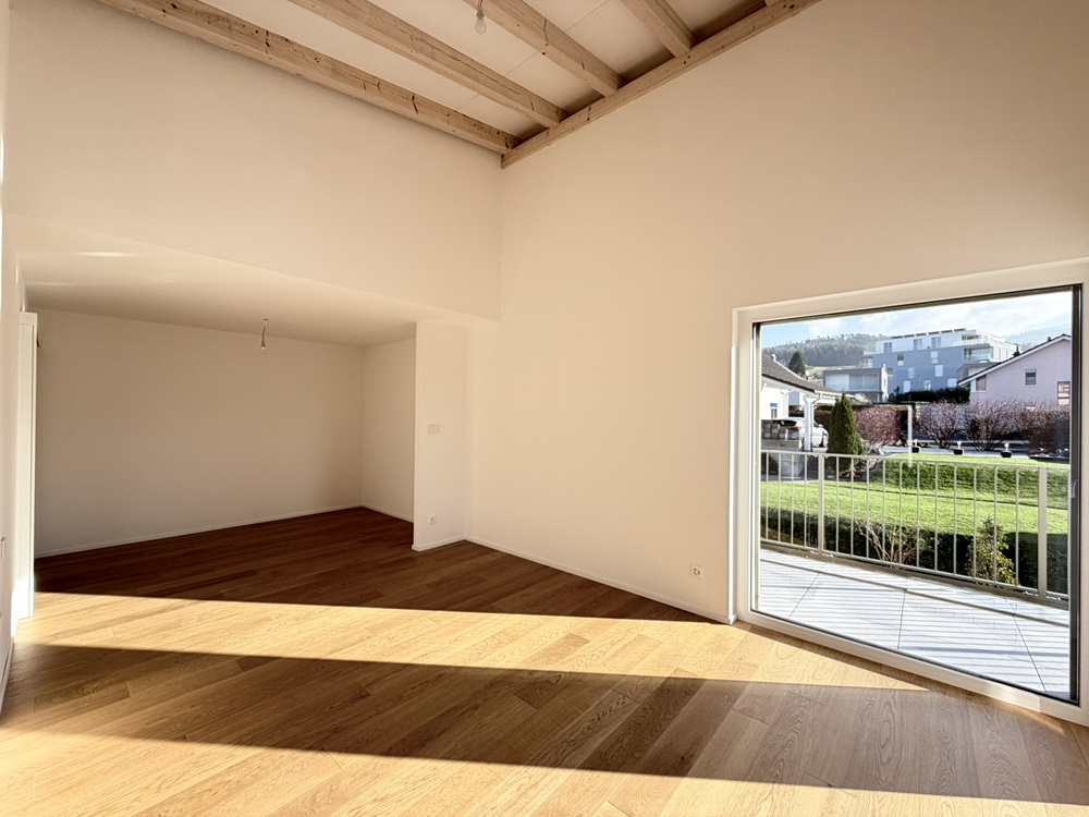 Heller Wohnraum mit Holzdecke und Balkonzugang