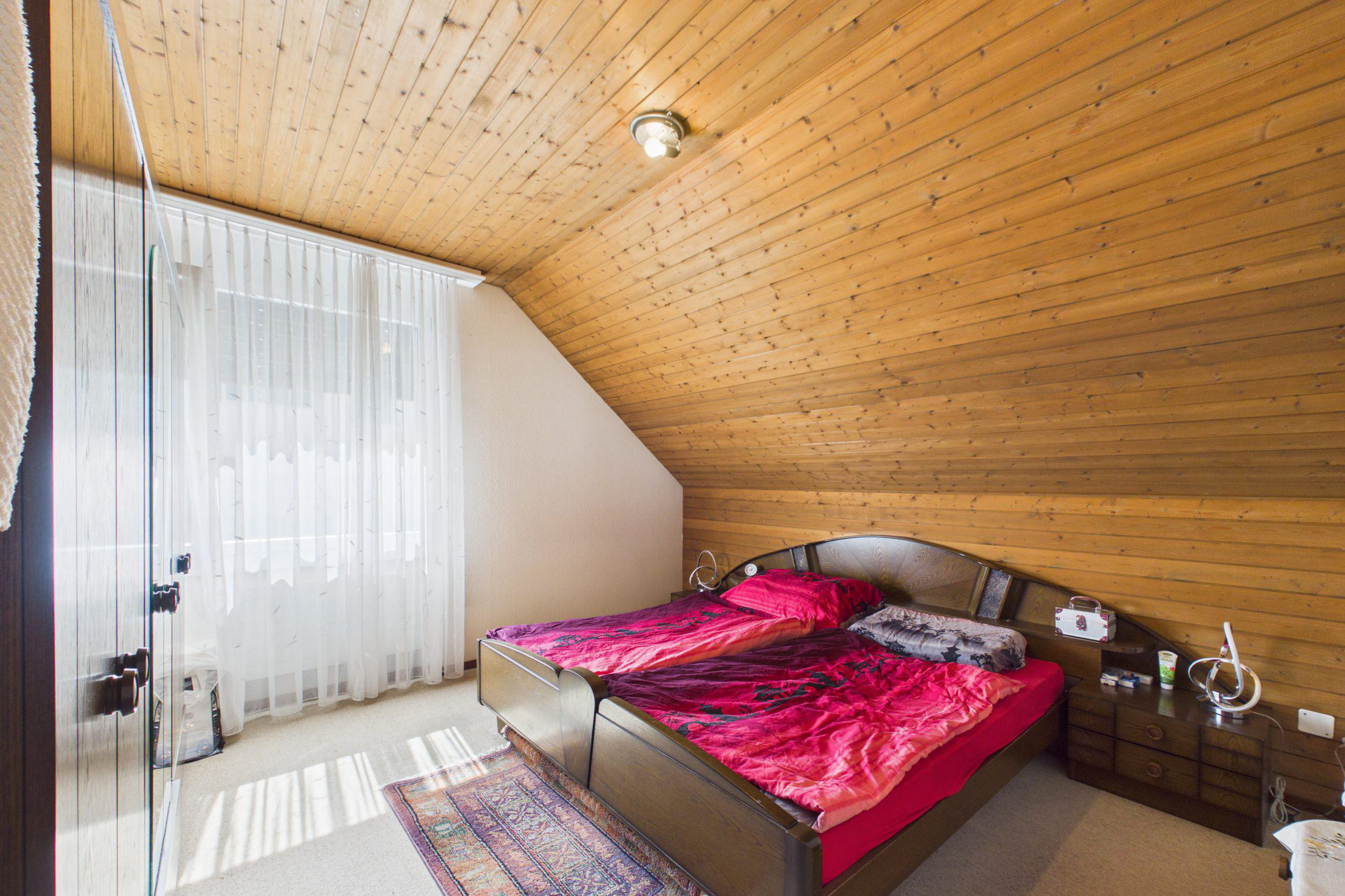 Dachgeschoss-Schlafzimmer mit Holzverkleidung