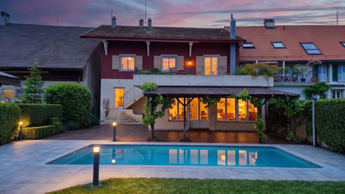 Abendliches Einfamilienhaus mit Pool und Terrasse