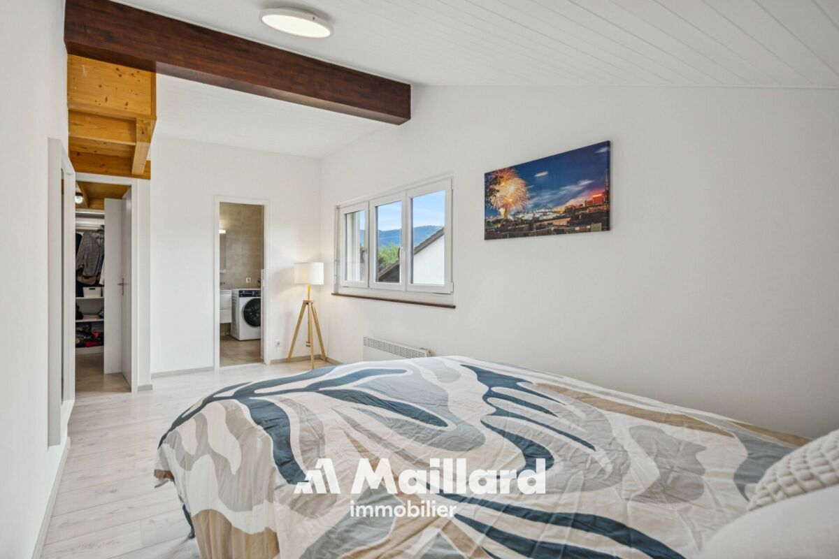 Helles Schlafzimmer mit Dachschräge und Balkon-/Fensterblick