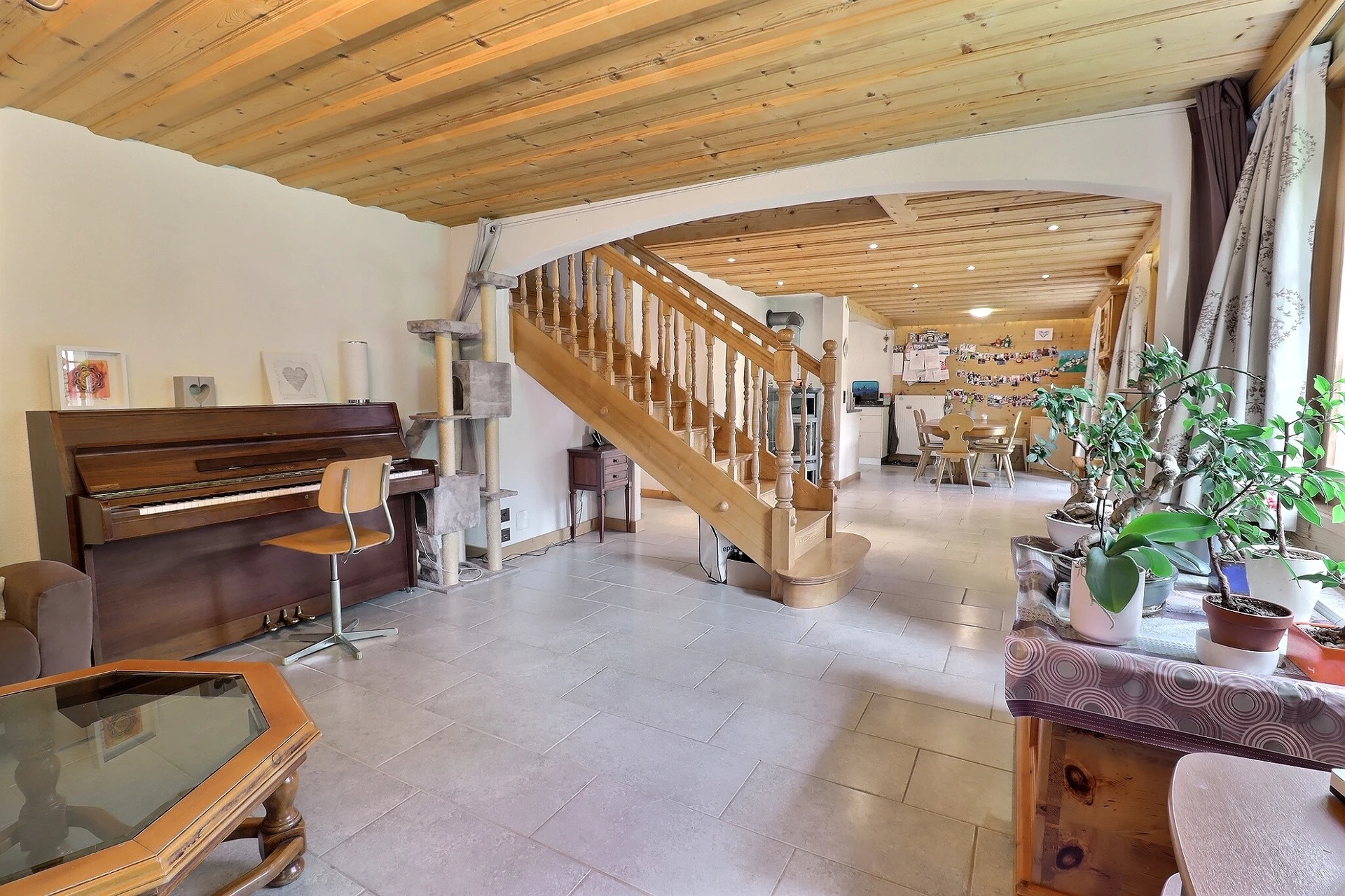 Heller Wohnraum mit Holztreppe und Klavier