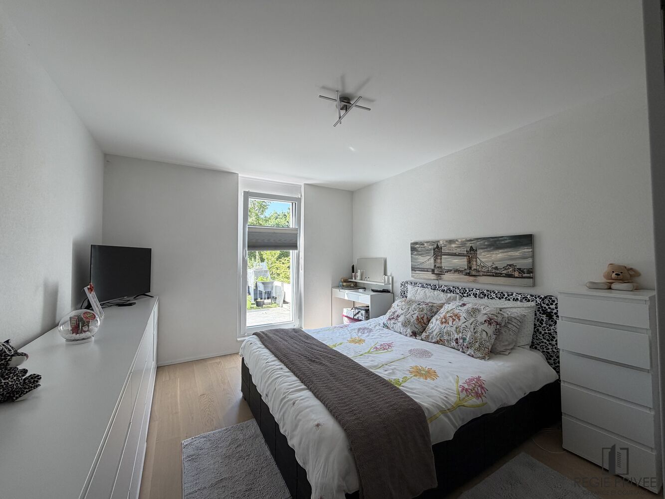 Helles Schlafzimmer mit Doppelbett und Blick in den Garten