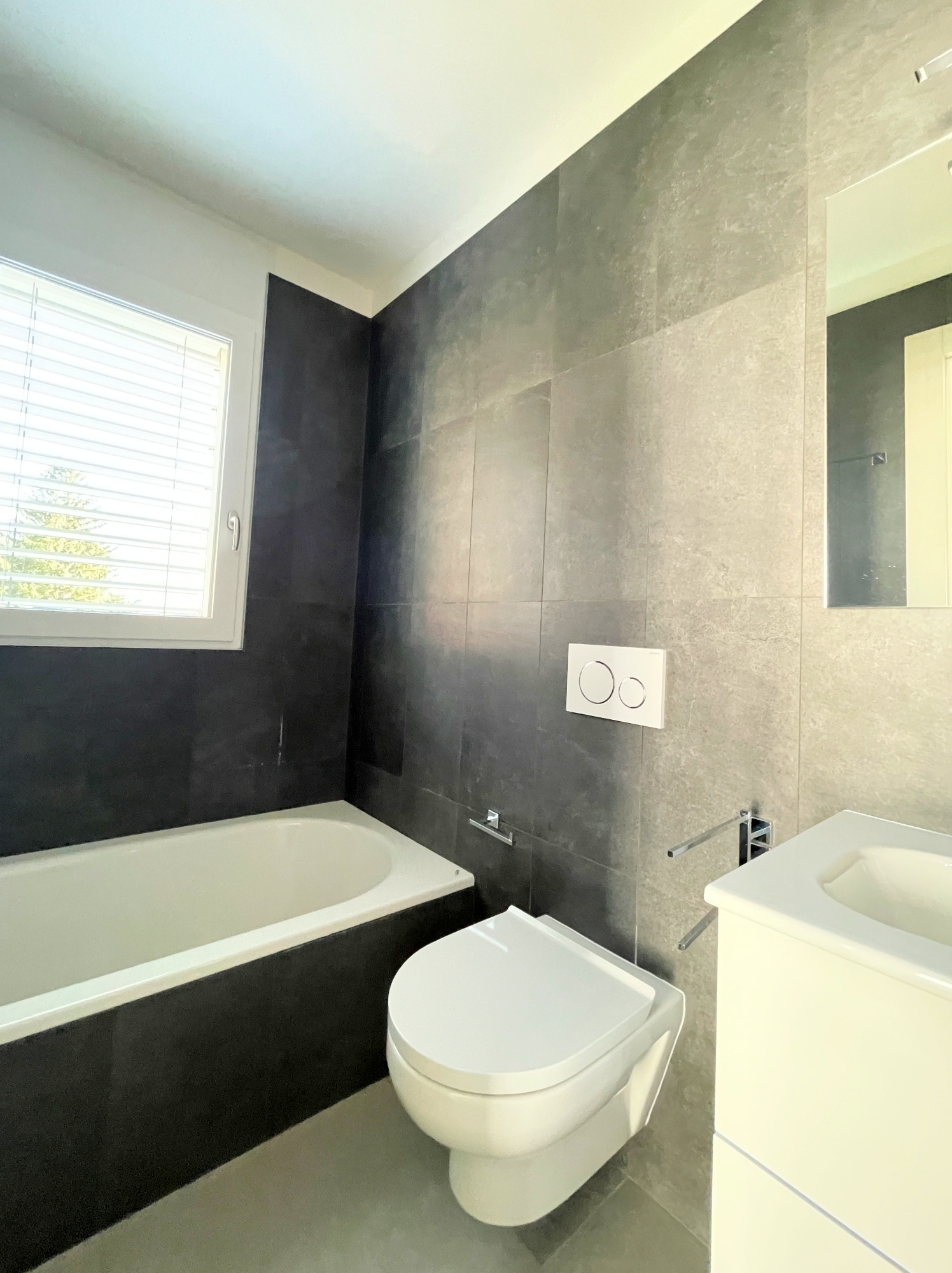 Modernes Badezimmer mit Badewanne und Wand-WC