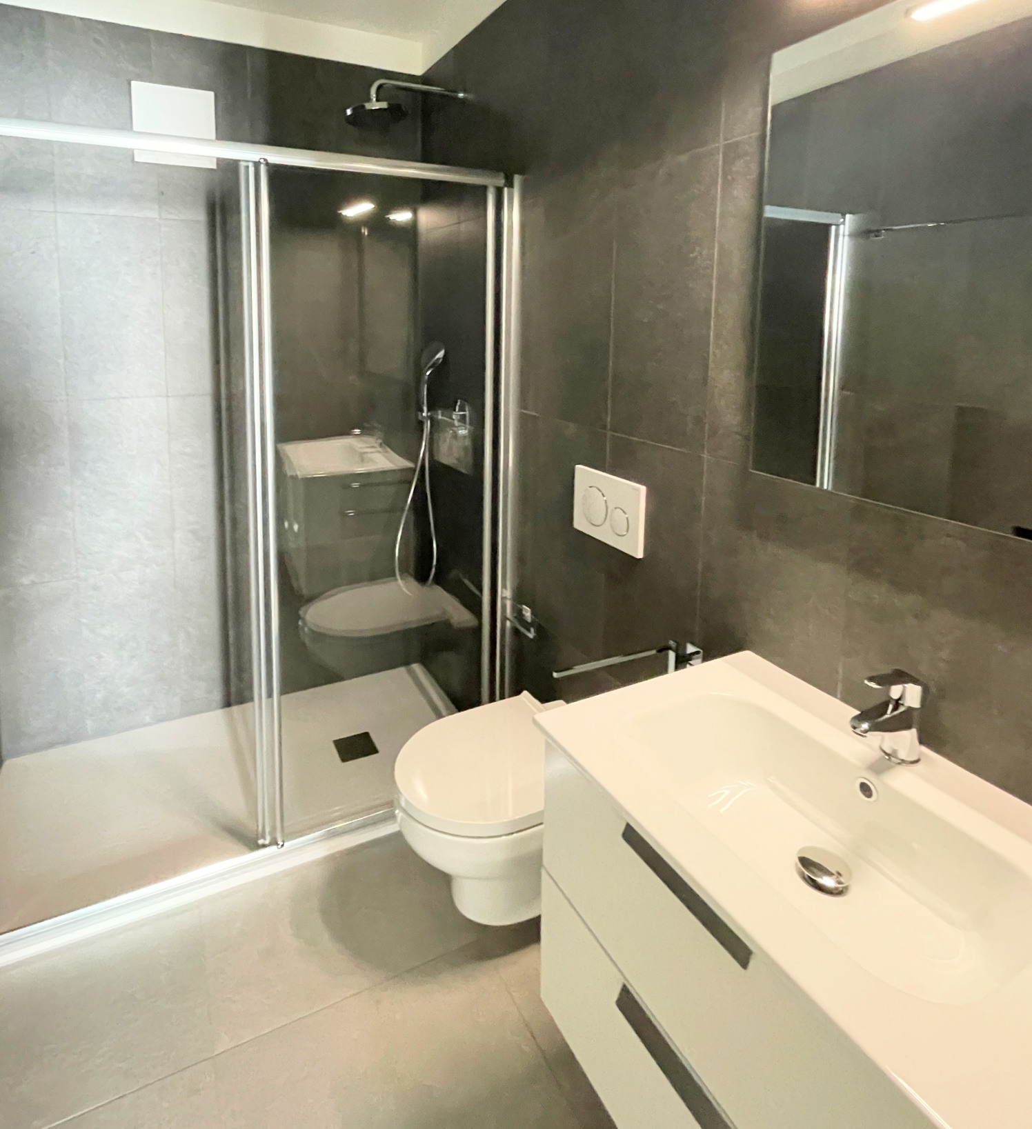 Modernes Badezimmer mit Dusche und Waschplatz