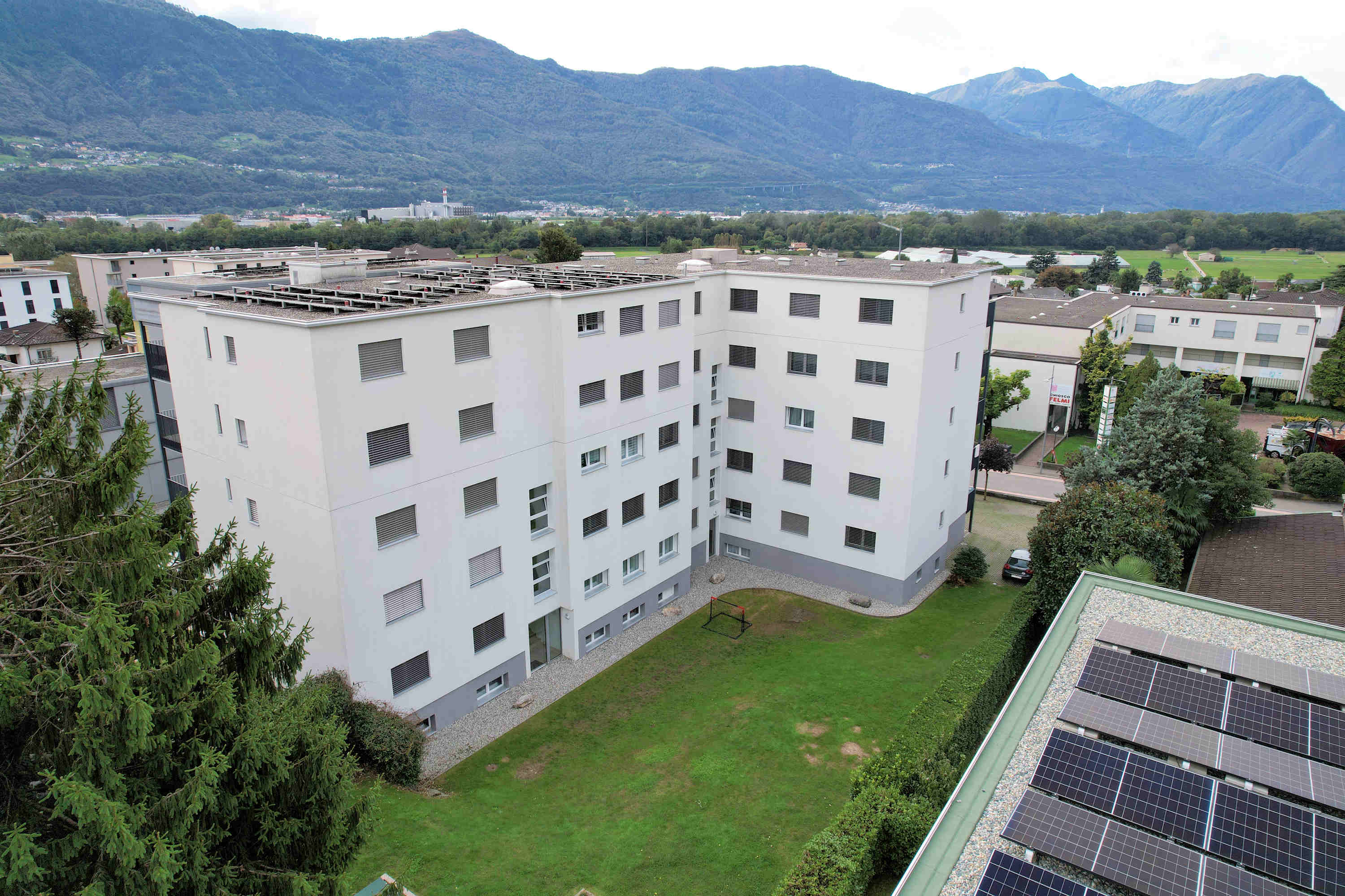 Außenansicht eines Mehrfamilienhauses mit Bergpanorama