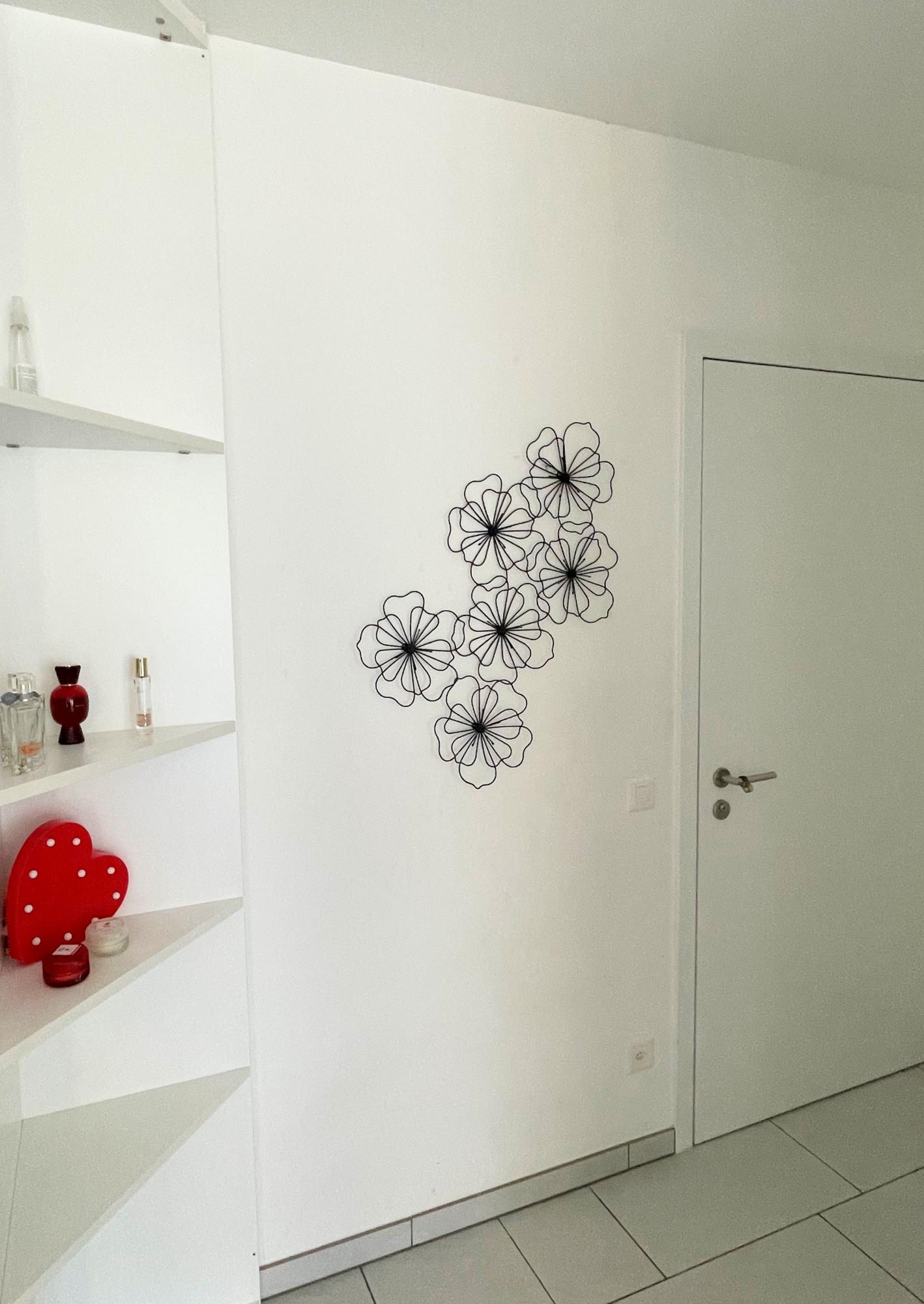 Heller Flur mit weißer Tür und Wanddeko