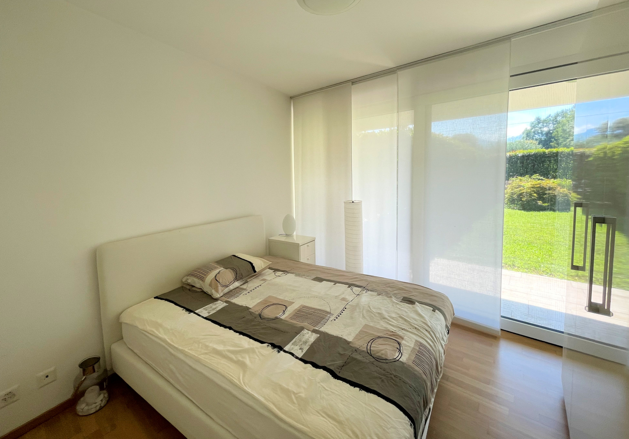 Helles Schlafzimmer mit bodentiefer Fensterfront