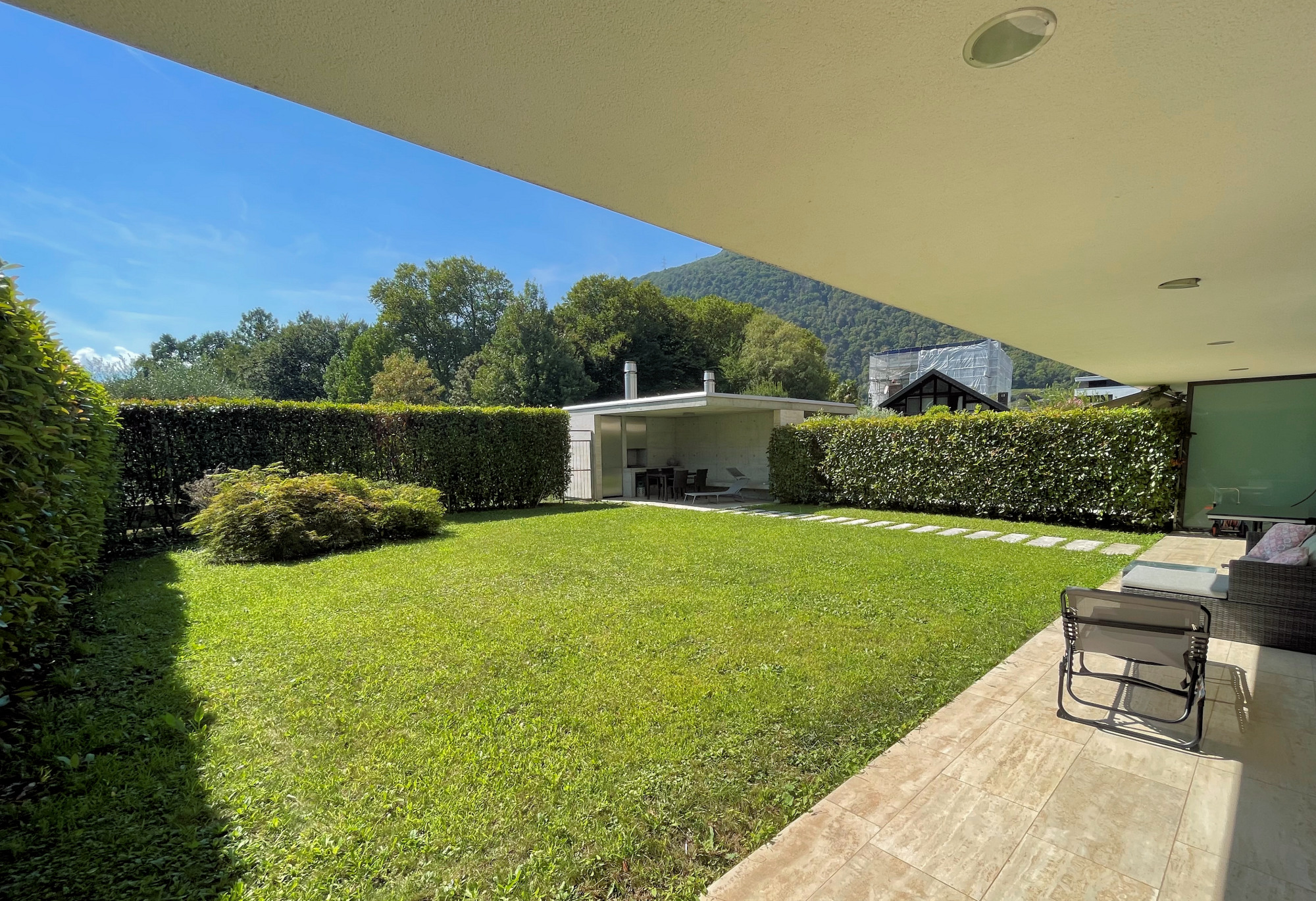 Großer Garten mit überdachter Terrasse und Bergblick
