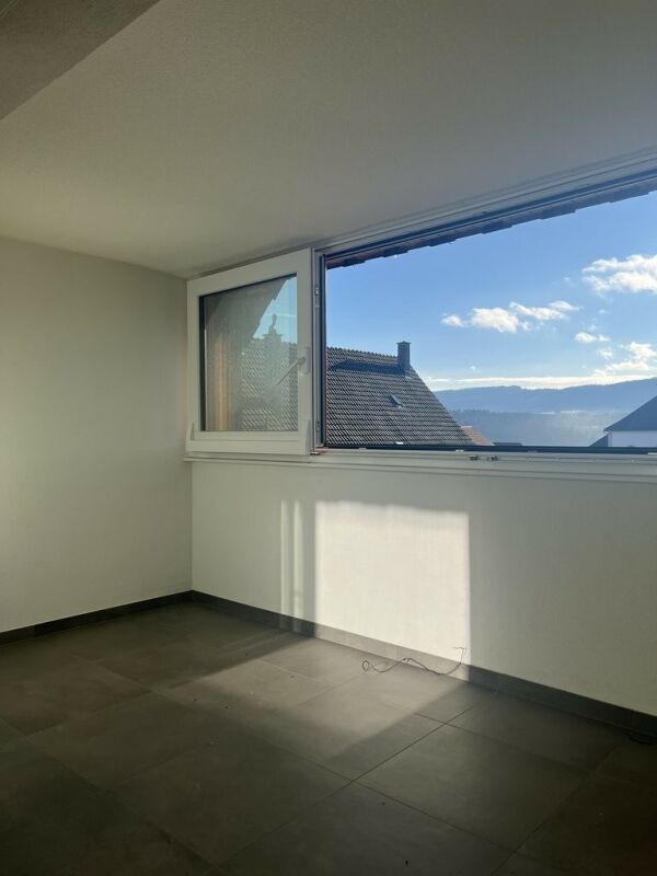 Leerer Raum mit großem Fenster und Bergblick