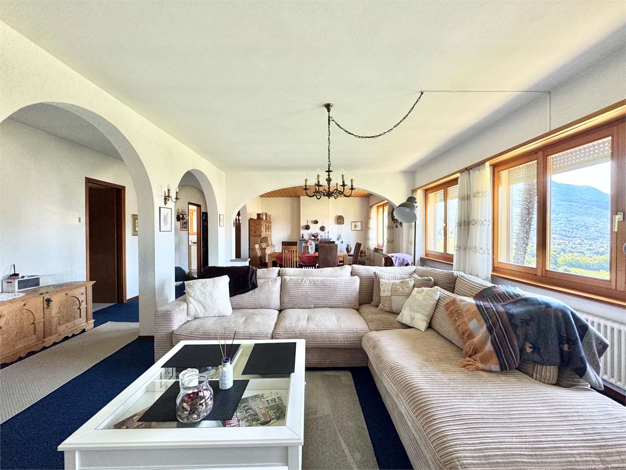 Wohnzimmer mit Blick ins Esszimmer und Bergausblick