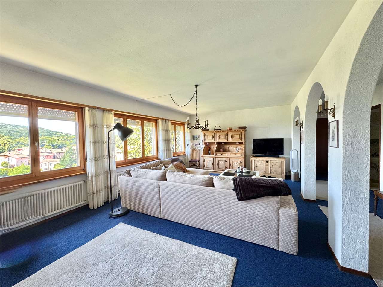 Wohnzimmer mit großer Fensterfront und Blick ins Grüne