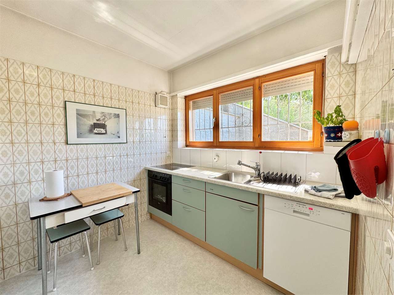 Helle Küche mit Fensterfront und kleinen Esstisch